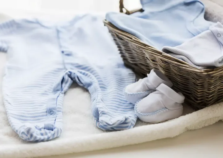 roupa de bebé ao pé de cesto de verga